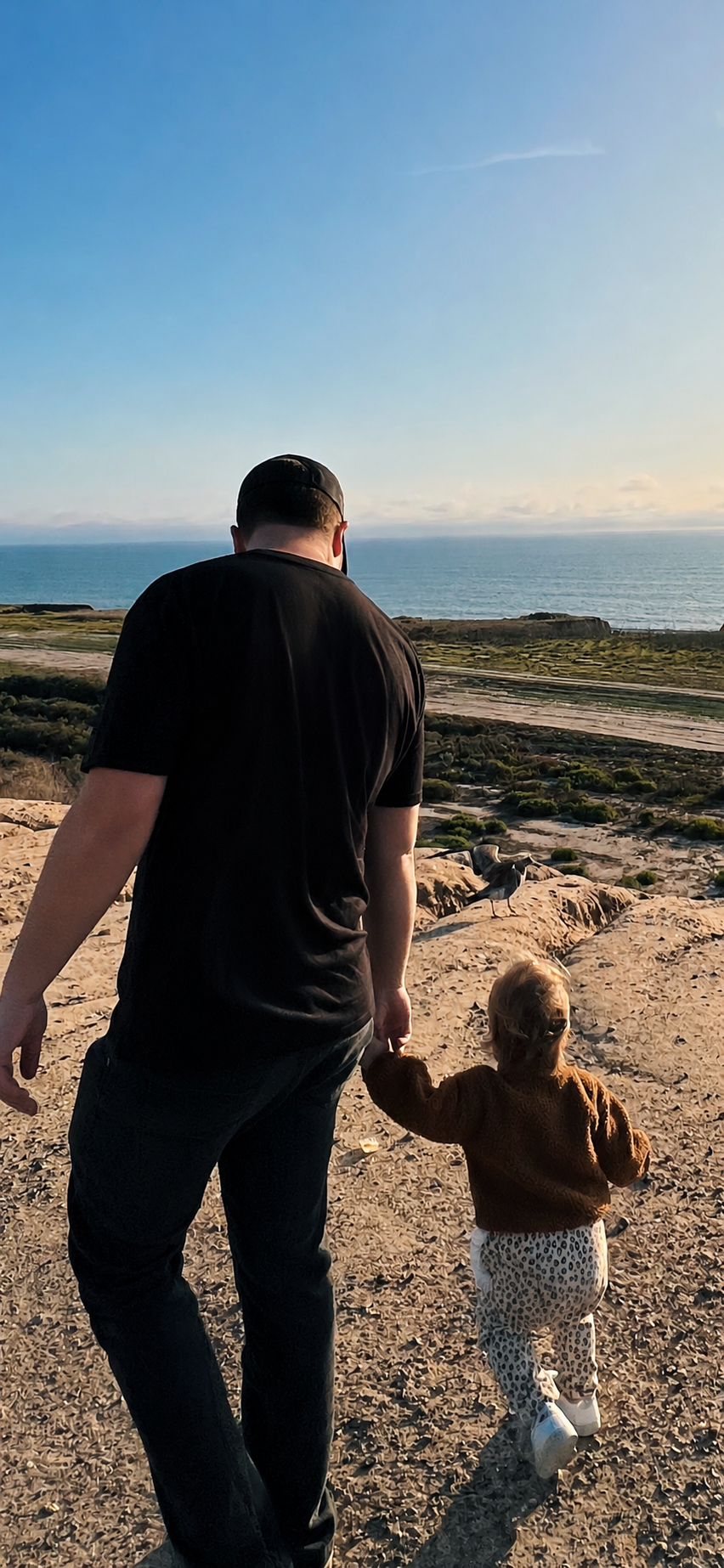 Alex walking on the coast with his daughter